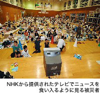 NHKから提供されたテレビでニュースを食い入るように見る被災者